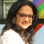 A woman with glasses and long hair.