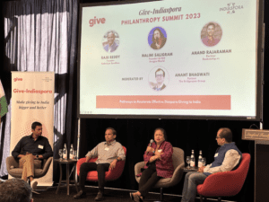 Four people are sitting in front of a screen.