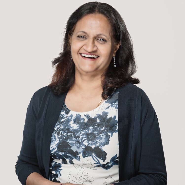 A woman standing in front of a white wall.