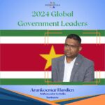 A man standing in front of the flag of suriname.