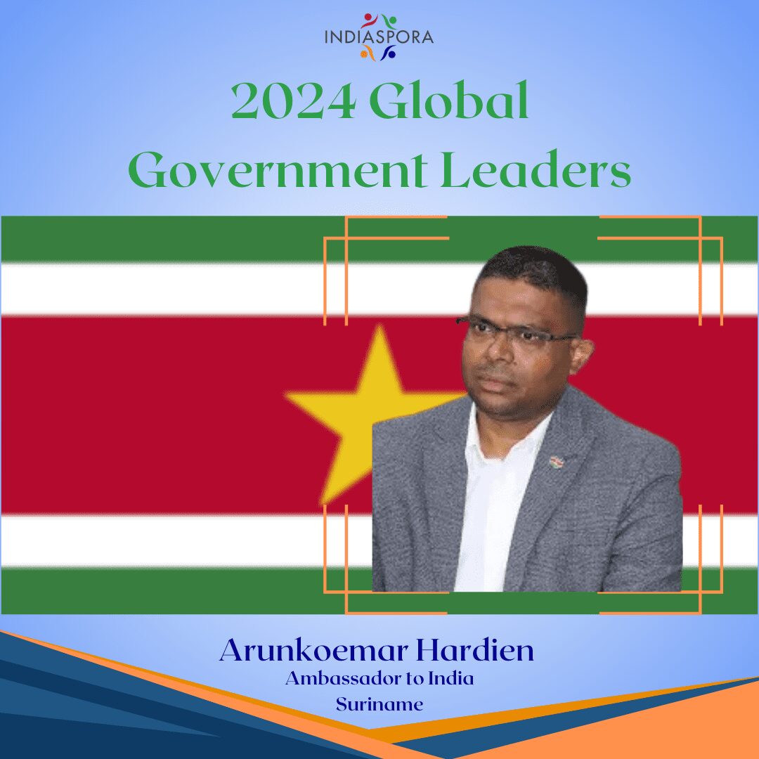 A man standing in front of the flag of suriname.