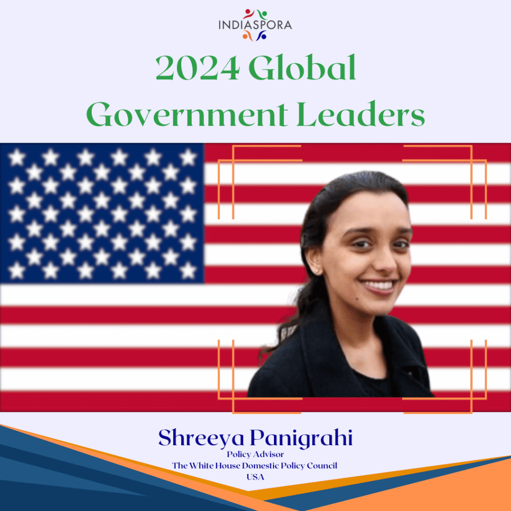 A girl is smiling in front of an american flag.