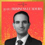 A man in suit and tie standing next to the words indiaspora 2 0 2 0 business leaders.