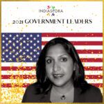 A woman standing in front of an american flag.