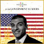 A man in suit and tie with american flag background