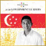 A man standing in front of the singapore flag.