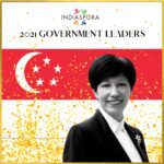 A woman standing in front of the singapore flag.