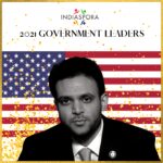 A man in suit and tie with american flag background