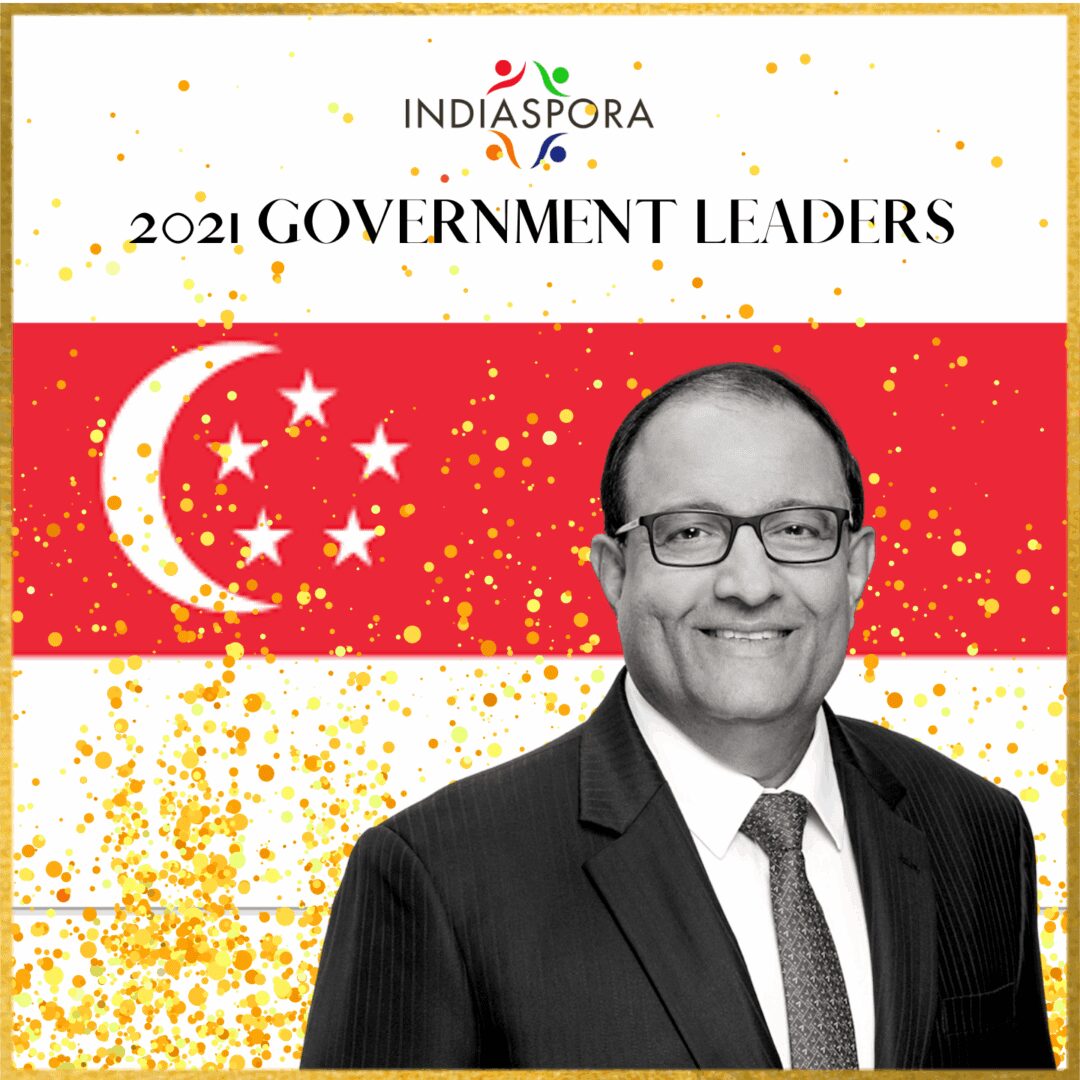 A man in suit and tie standing next to an asian flag.