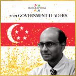A man in glasses and tie standing next to an asian flag.