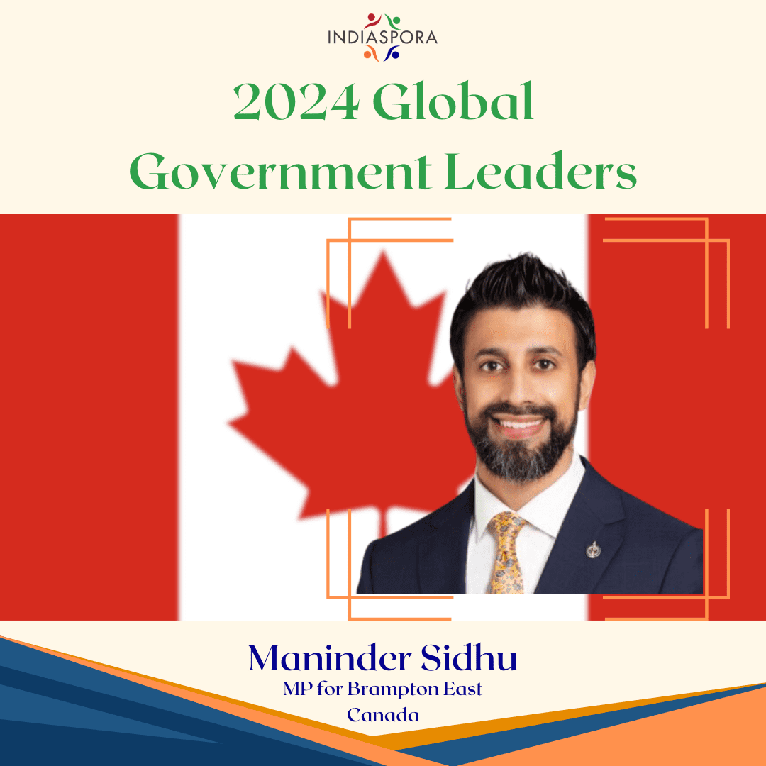 A man in a suit and tie standing next to the canadian flag.
