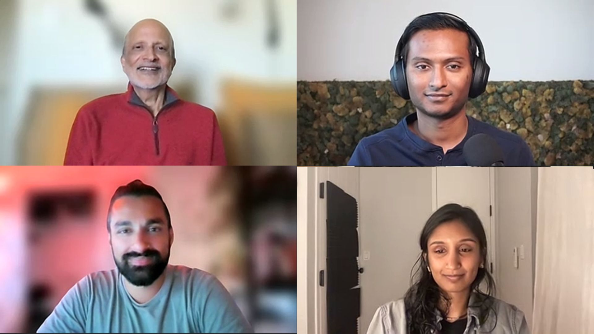 Four people are smiling and one is wearing headphones.