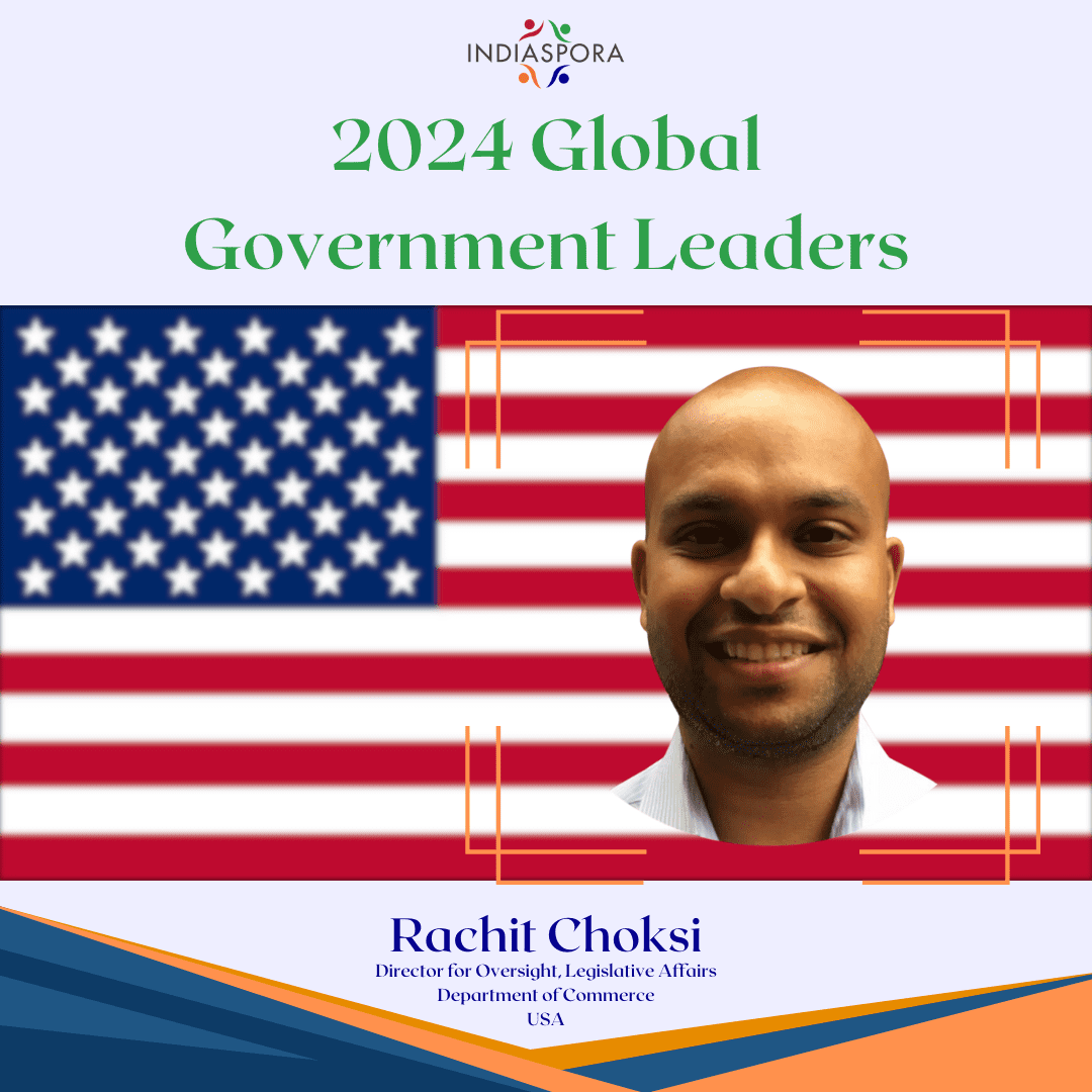 A man is smiling in front of an american flag.
