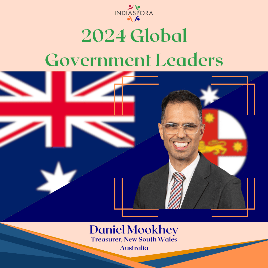 A man in a suit and tie with the australian flag behind him.