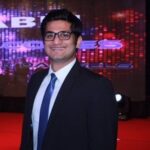 A man in suit and tie standing on the red carpet.