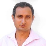A man in pink shirt and black hair.