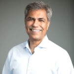 A man with grey hair and a white shirt