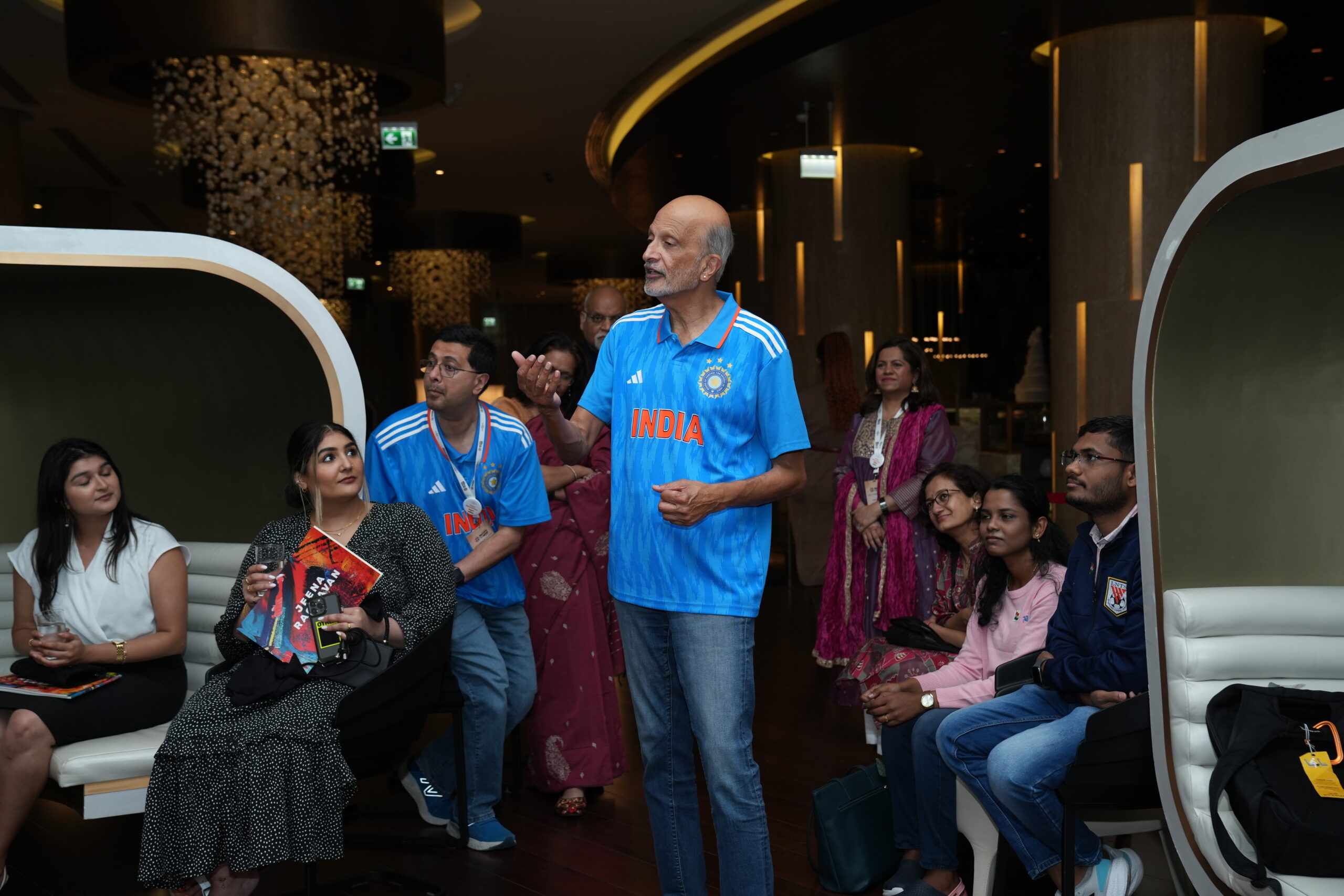 A man in blue shirt standing next to people.