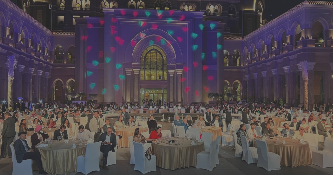 A painting of people sitting at tables in front of a building.