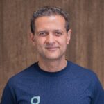 A man in blue shirt smiling for the camera.