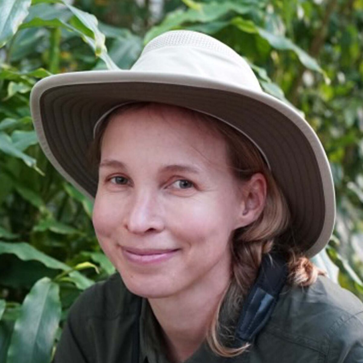 A woman wearing a hat and smiling for the camera.