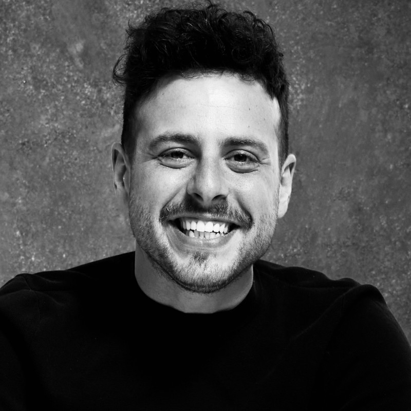 A man with a beard and mustache smiling for the camera.