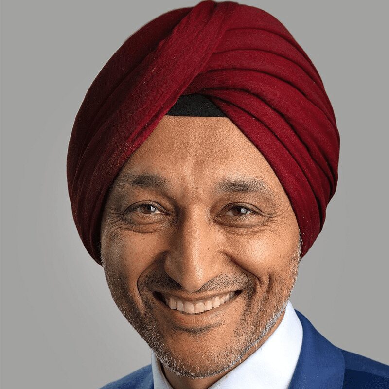 A man with a turban on smiling for the camera.