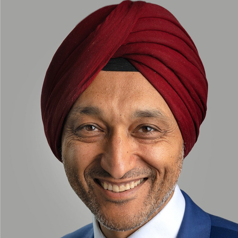 A man with a turban on smiling for the camera.