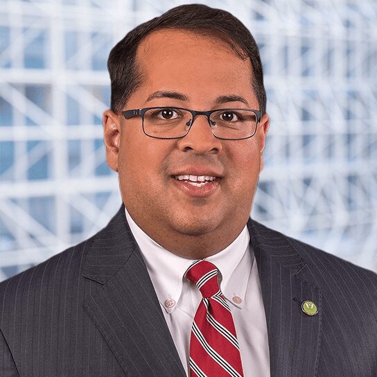 A man in a suit and tie standing next to a building.