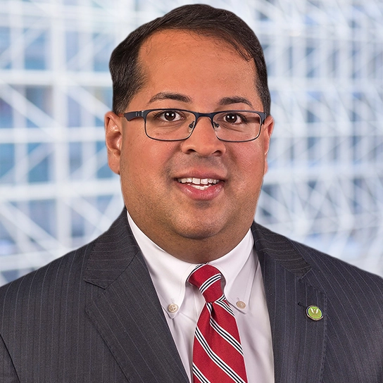 A man in a suit and tie standing next to a building.