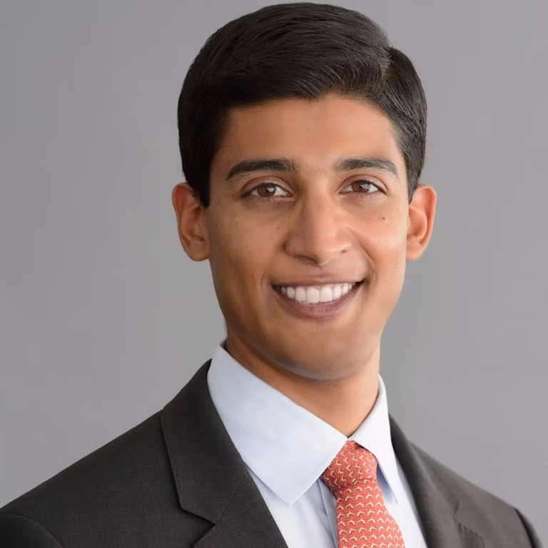 A man in suit and tie smiling for the camera.