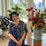 A woman standing in front of some flowers.