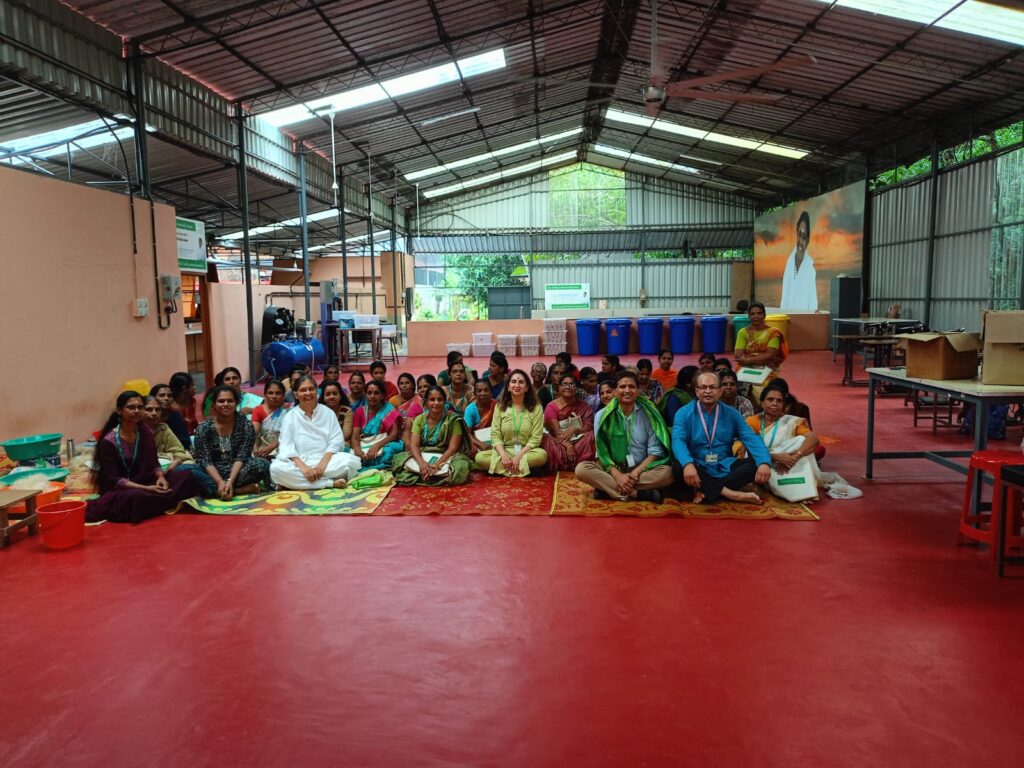A group of people sitting on the ground in front of a building.