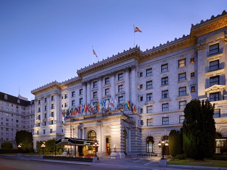 Historic hotel facade with international flags displayed.