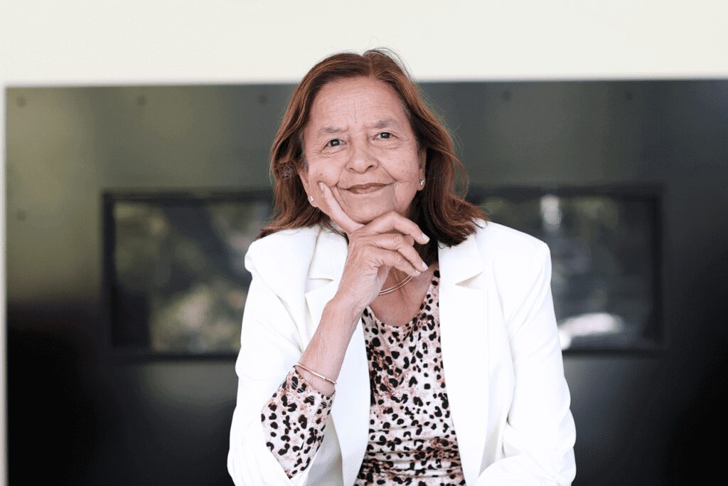 Woman in white jacket, thoughtful expression.