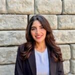 Smiling woman in blazer against stone wall