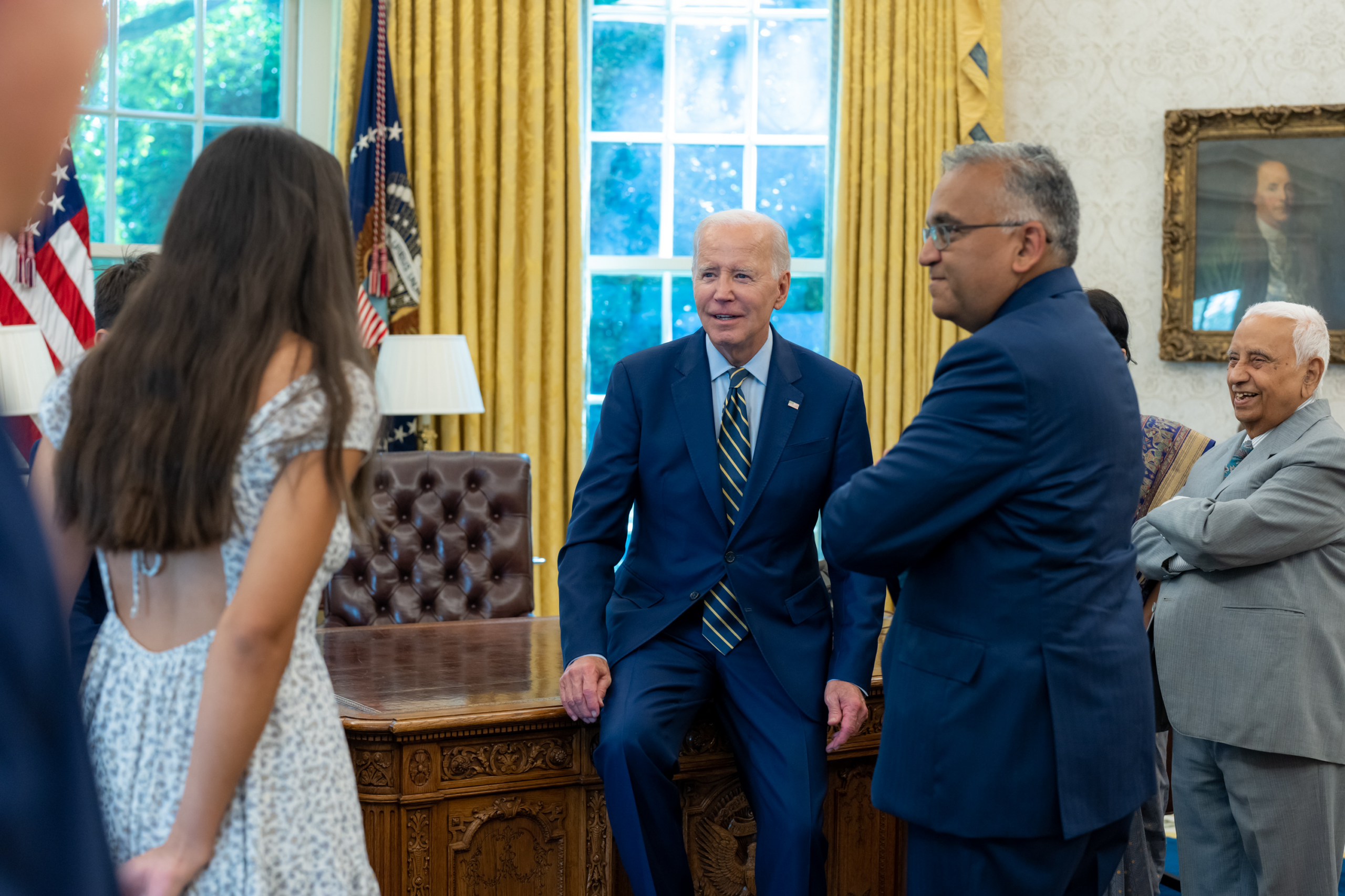 Group gathered for meeting in Oval Office|Man in suit shaking elderly woman's hand|Two smiling people shaking hands in Oval Office|Smiling man in blue suit, autumn background|Smiling professional businesswoman in office