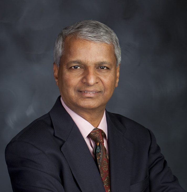 Elderly man in suit with neutral background.