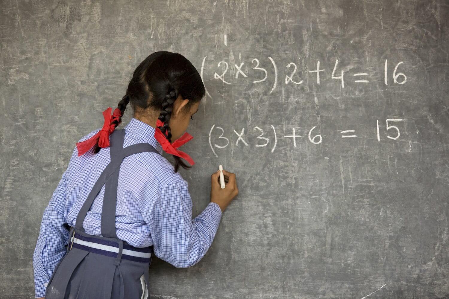 Girl solving math problems on chalkboard.|Woman making incense sticks, smiling outdoors.