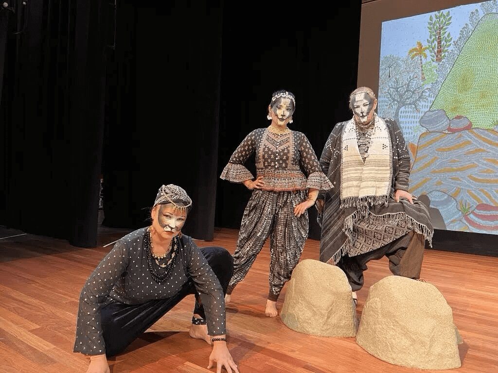 Three women in costumes on a stage