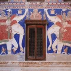 A wall with two paintings on it and one of them has an open door.|A wall with paintings on it and an open door.|A building with many paintings on the side of it|A wall with paintings on it and windows