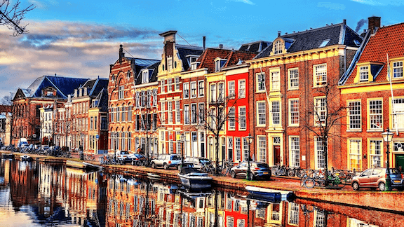 A row of houses on the side of a river.