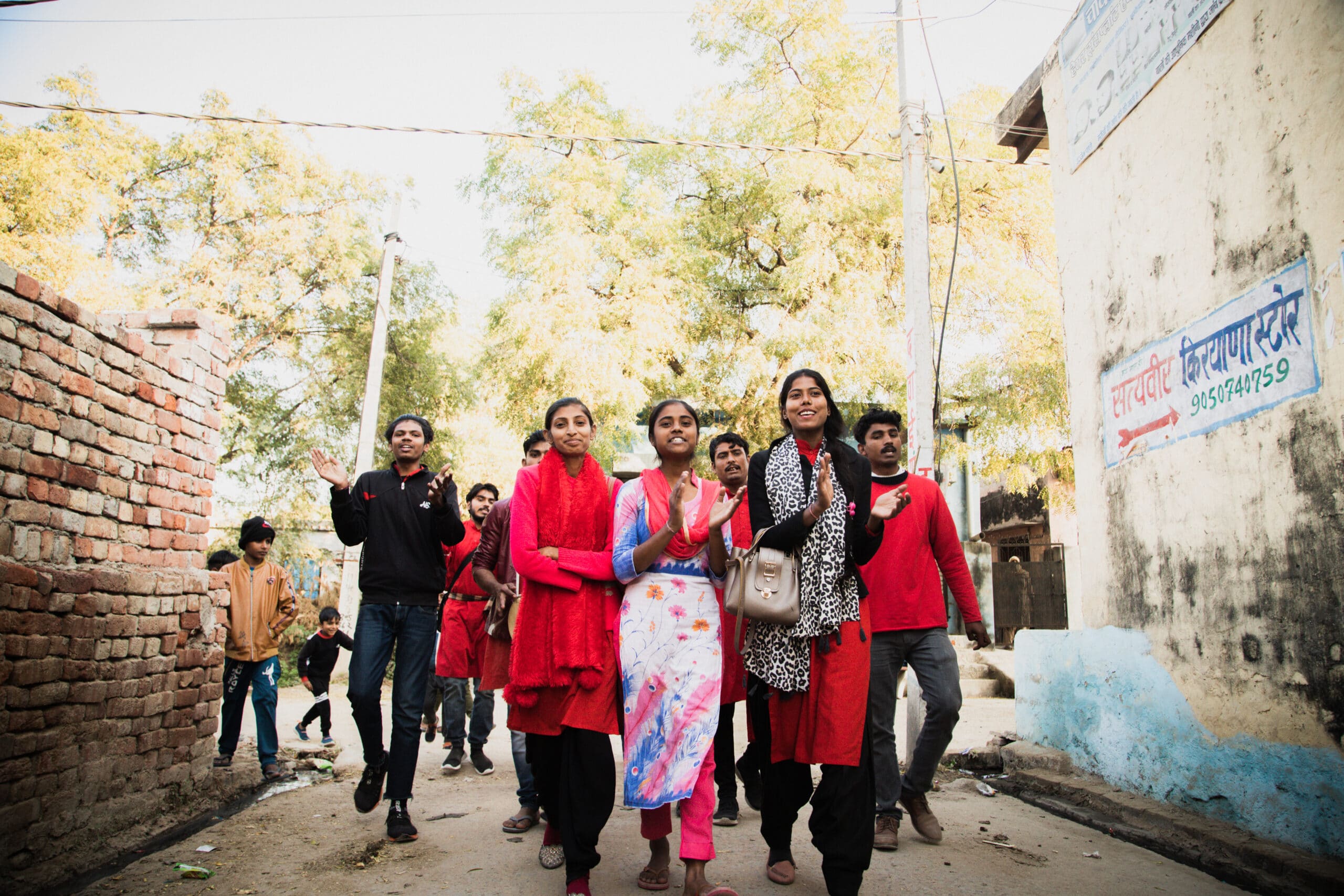 A group of people walking down the street.|A red background with the words " aktthrough " in white.|A group of women sitting in front of a crowd.|A group of people sitting in front of a wall.