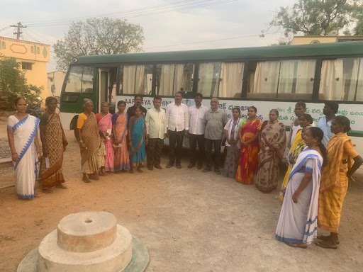 A group of people standing in front of a bus.