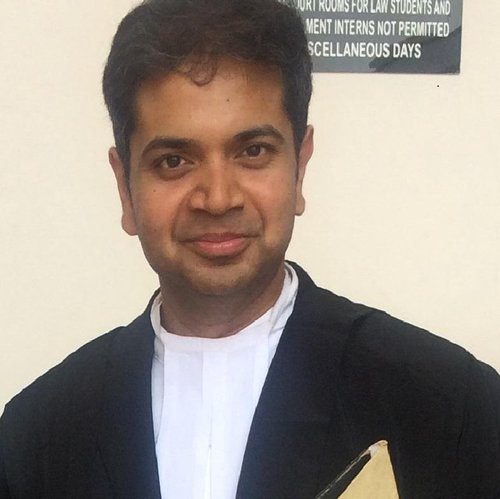 A man in black jacket holding a book.