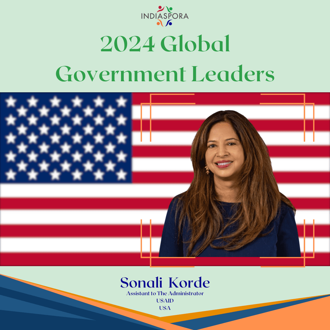 A woman standing in front of an american flag.