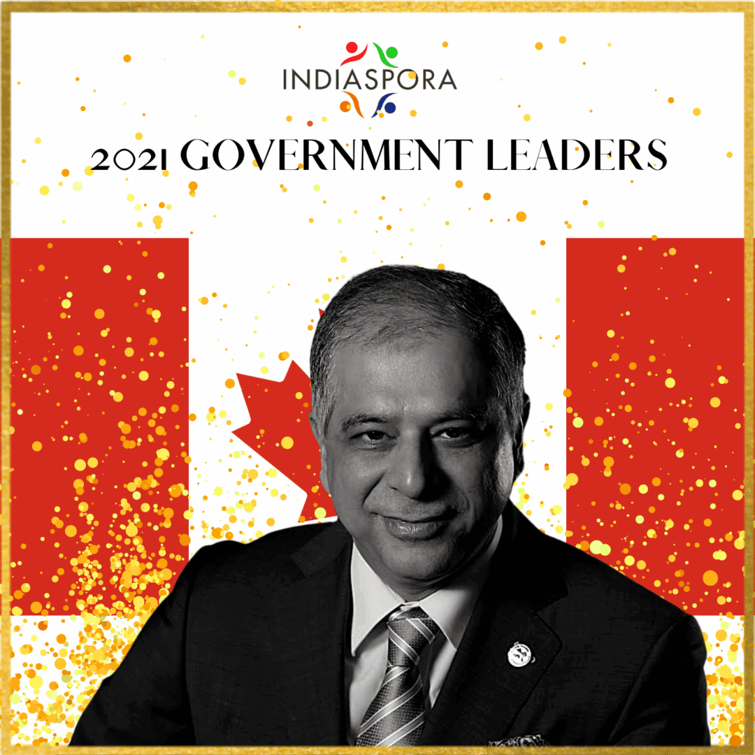 A man in suit and tie with canadian flag background.