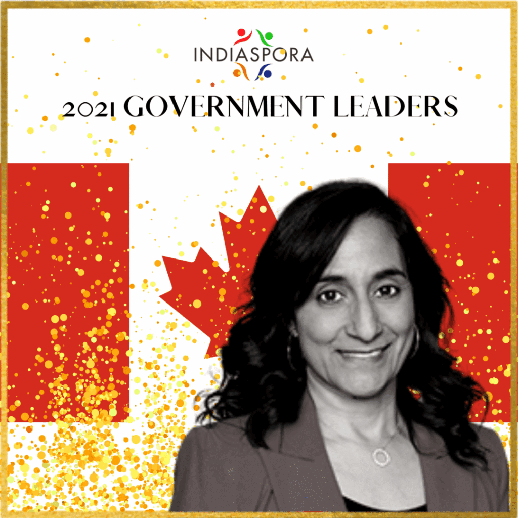 A woman standing in front of the canadian flag.