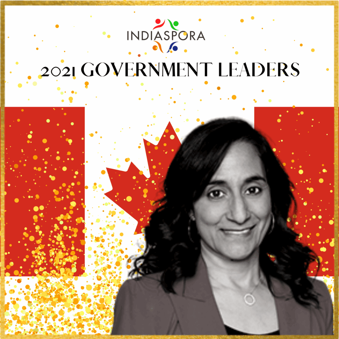 A woman standing in front of the canadian flag.