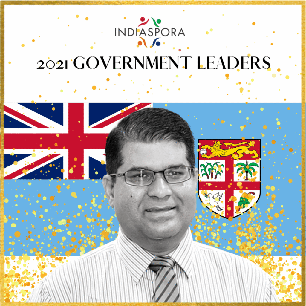 A man with glasses and tie in front of the flag.|A man with glasses and tie in front of the flag.